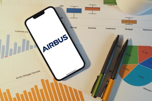 Avion Airbus devant un graphique boursier avec tendances haussières et analyse sur tablette numérique