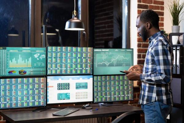 Moderner Arbeitsplatz für die technische Analyse mit Monitoren am Schreibtisch
