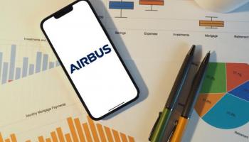 Avion Airbus devant un graphique boursier avec tendances haussières et analyse sur tablette numérique