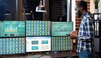 Moderner Arbeitsplatz für die technische Analyse mit Monitoren am Schreibtisch